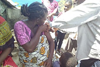 Une femme se fait administrer un vaccin antitétanique par un agent de santé communautaire.